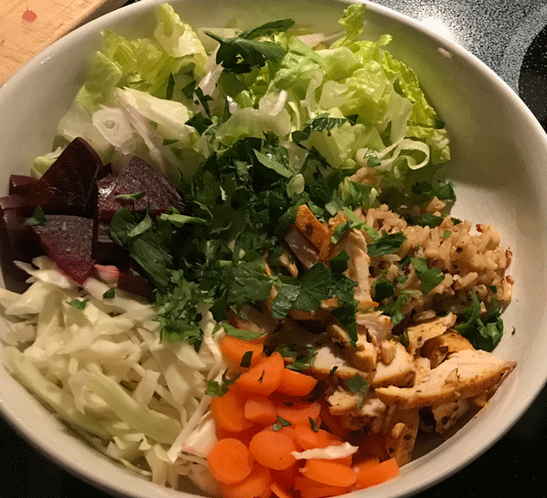 Photo of salad bowl with beets, carrots, lettuce, chicken, rice